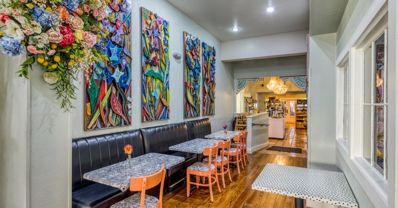 Interior, floral wall decoration, single booth seating with tables and chairs