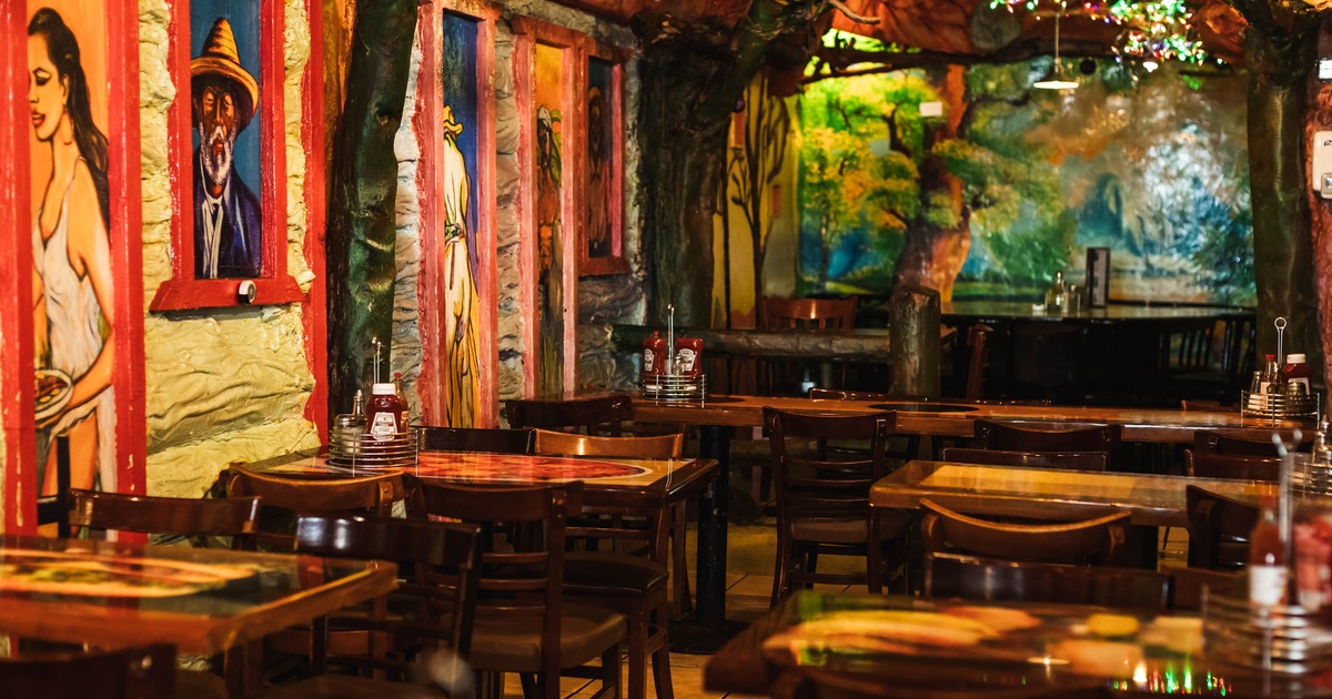 Interior, dining area, wooden top tables for four, paintings on the wall, tile flooring