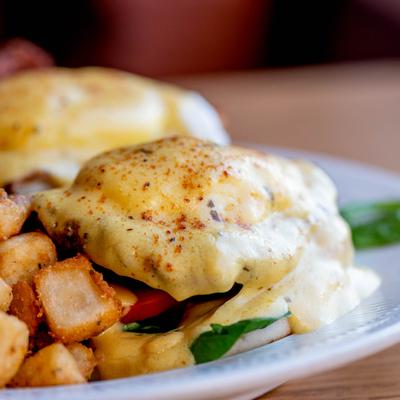 Luiciana Eggs Benedict with fried chicken and home fries on the side.
