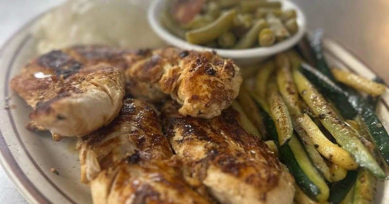Grilled chicken with zucchini and green beans on a plate