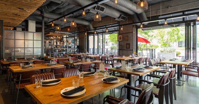 Interior, seating area, wooden top tables with chairs, large folding doors