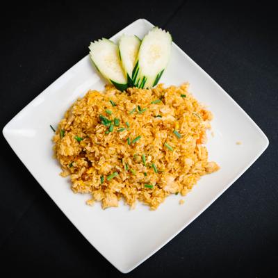Thai fried rice with cucumber and chive garnish.