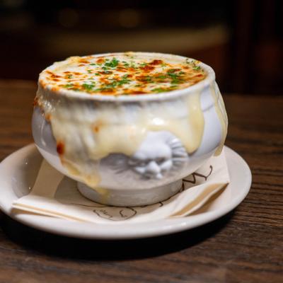 Bowl of French onion soup with melted cheese.