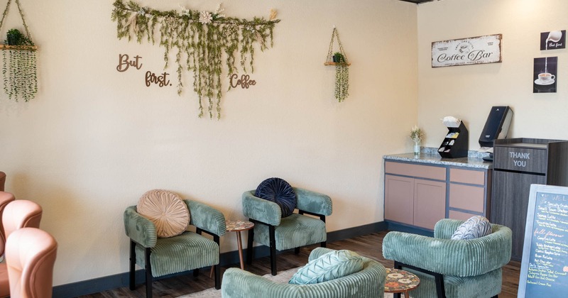 Coffee shop interior with vintage-style green chairs and decorative greenery