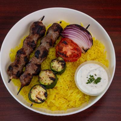Steak Kabob with veggie kabob, served over a bed of rice with tzatziki.