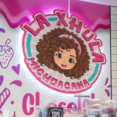Laxuela Michoacana logo featuring a cartoon girl with curly hair.