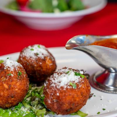 Deep fried rice balls, with marinara sauce.