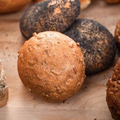 A variety of fresh rolls on a wooden table, close up.