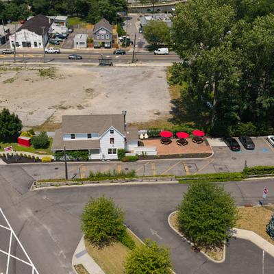 Aerial view of the building with roadway, landscaped median islands and green trees.