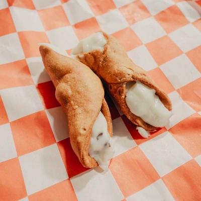 Italian Cannoli on a red and white checkered paper.