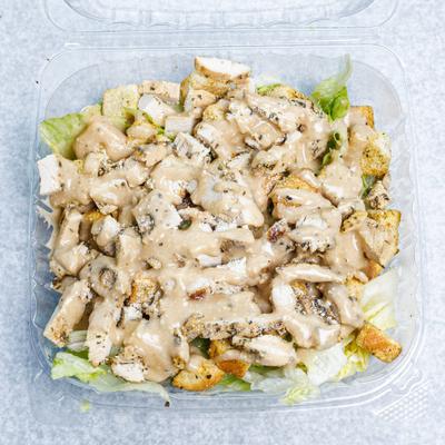 Chicken Caesar Salad served in a plastic container.