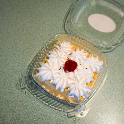 Tres Leches topped with whipped cream and garnished with a cherry.