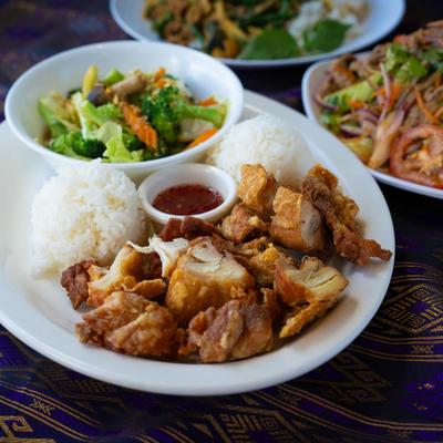 A plate with Mix Vegetables Stir-Fried and Fried Chicken, accompanied with salad plates.