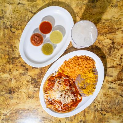 Chile relleno with rice, refried beans, salsas, tortillas, and a drink.