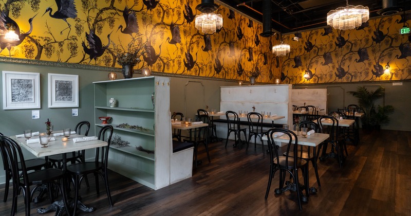Interior, dining area, tables with chairs, ready for guests, colorful wallpapers, chandeliers