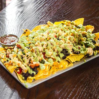 Nachos, with black beans, cheddar, Jack cheese, pico de gallo, and avocado sauce.