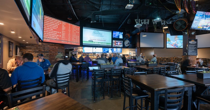 Interior, guests chatting and enjoying their drinks, hanging tv screens