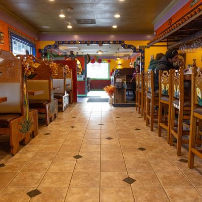 A view of dining booths on the left and bar chairs on the right.