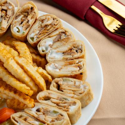Chicken shawarma wrap slices served with seasoned crinkle-cut fries.