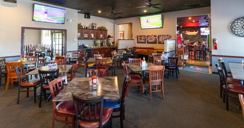 Interior of a restaurant with multiple wooden tables and chairs