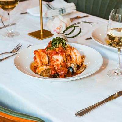 Seafood soup with clams, shrimp, calamari, mussels, and a glass of wine.