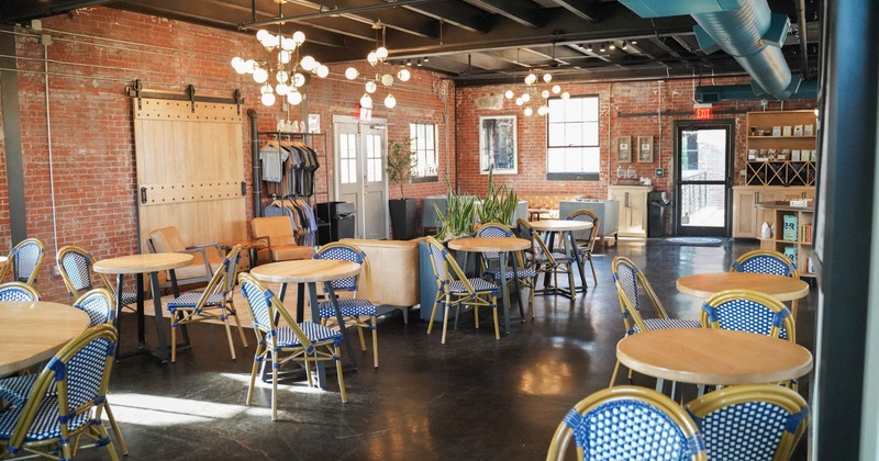 Interior, seating area, round tables for two, lounge area in the back, exposed red brick