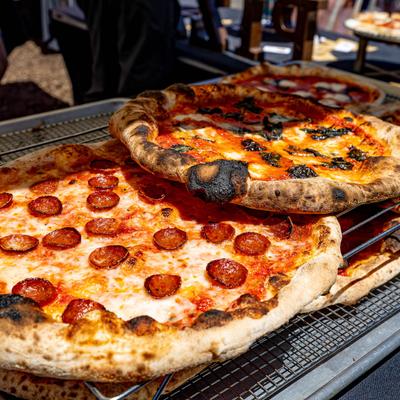 Baked pizzas with pepperoni and basil on wire racks.
