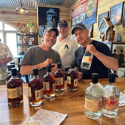 People posing for a photo with bottles.