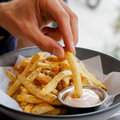 House Cut Fries, a customer dipping a fry in the sauce.