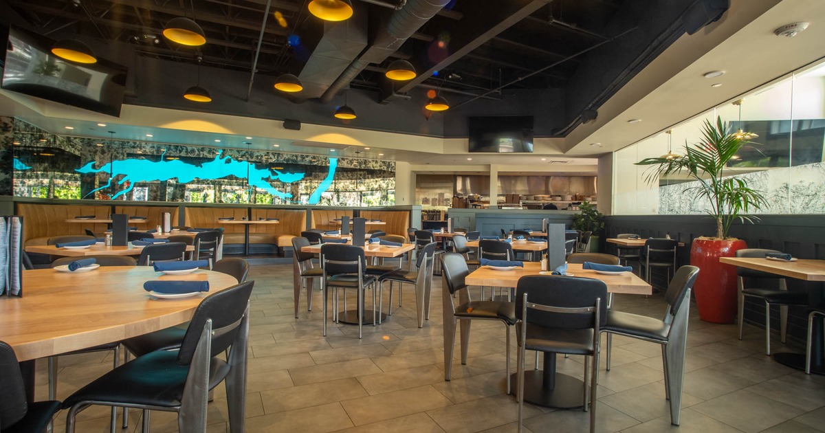 Interior with wooden tables, chairs, and a vibrant blue map on the wall