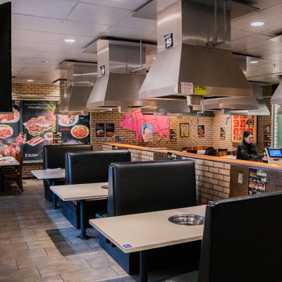 Restaurant interior with booths and grill tables.