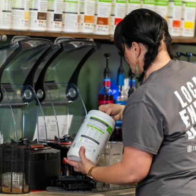 Bartende making a shake behind the bar.