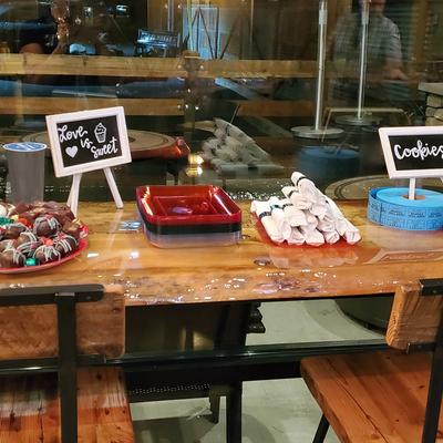 A wooden table displays treats with signs.