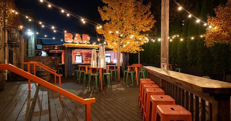Patio, high tables and chairs with bar in the back
