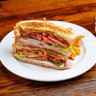 Turkey club sandwich with fries.