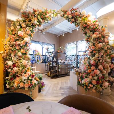 Interior, a massive archway completely covered in lush pink, peach, and white flowers.