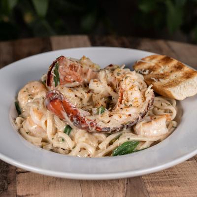 Lobster and shrimp pasta dish served with toast on the side.