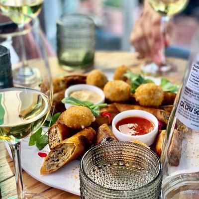 Rolled pastry with meat, two dips and a glass of white wine