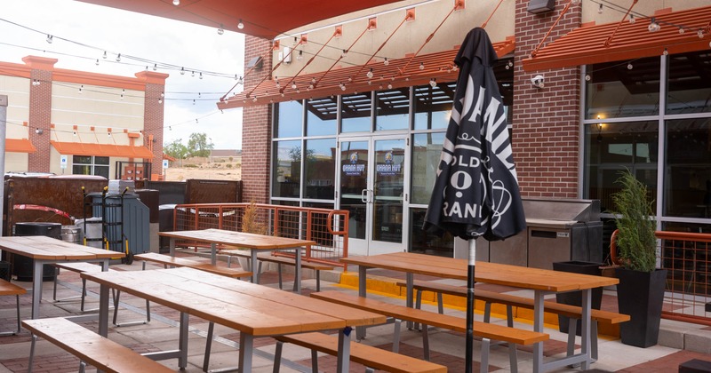 Exterior, covered seating area, wooden top tables and benches, hanging lanterns