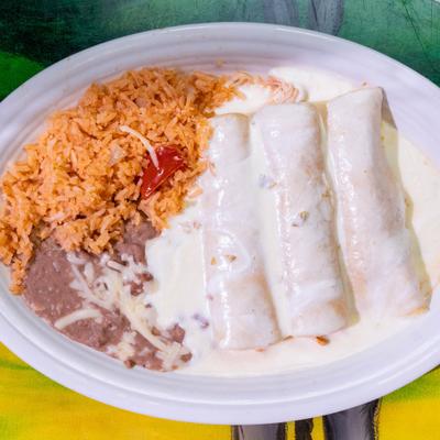 Enchiladas smothered in cheese sauce, served with rice and beans.