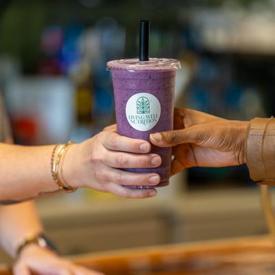 Two people handing each other Very Berry shake.