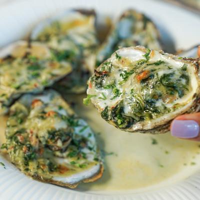 Baked oysters with herbs and melted cheese.