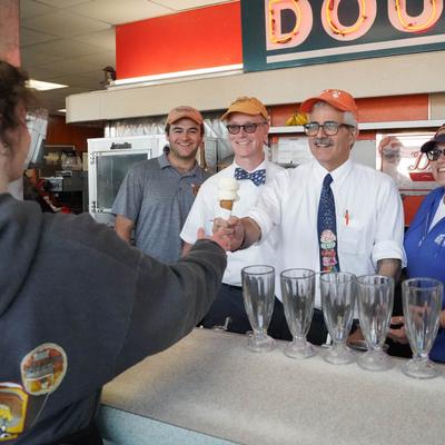 Doumar family behind counter serving ice cream cone.