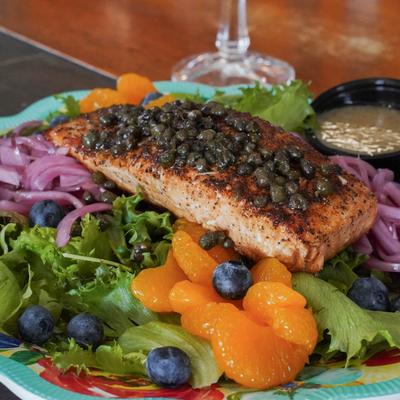 Grilled salmon topped with capers, served over mixed greens. blueberries, and red onions.