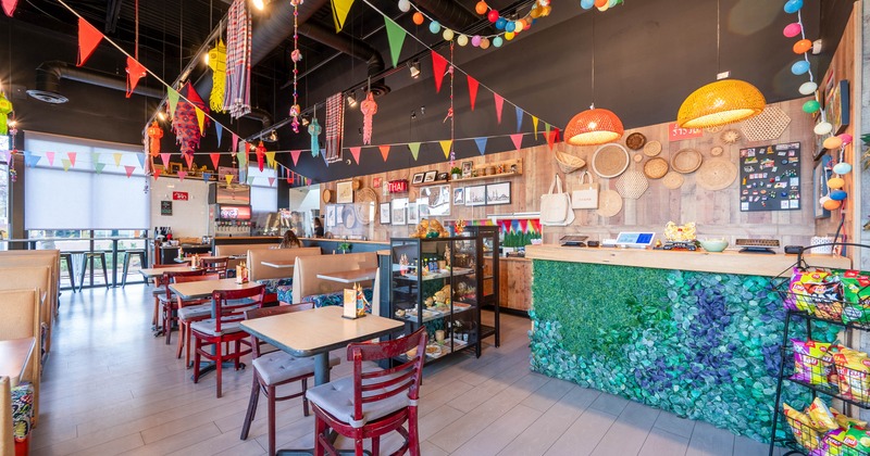 Colorful, eclectically decorated interior with tables, chairs, hanging decorations and counter