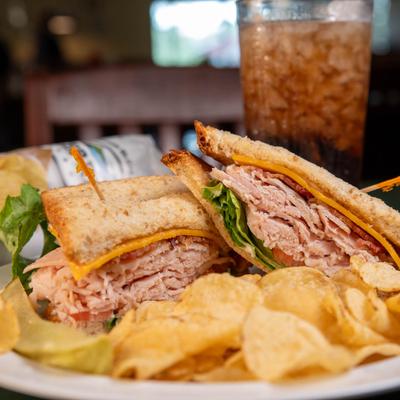 Turkey, Bacon & Cheddar sandwich served with potato chips.