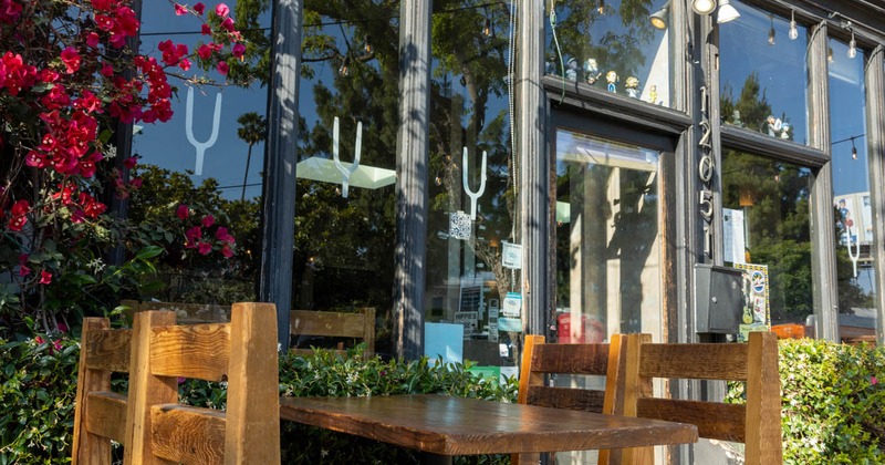Exterior, diner table in front the entrance, front view of restaurant, lower angle