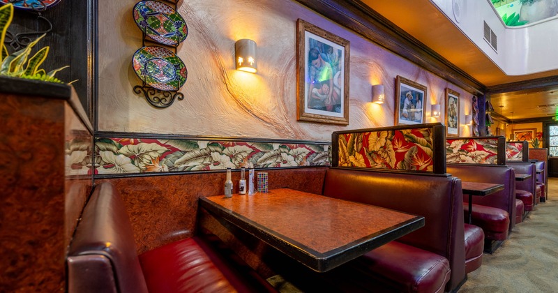 Interior, dining area, leather seating booths with tables, framed paintings as a decoration