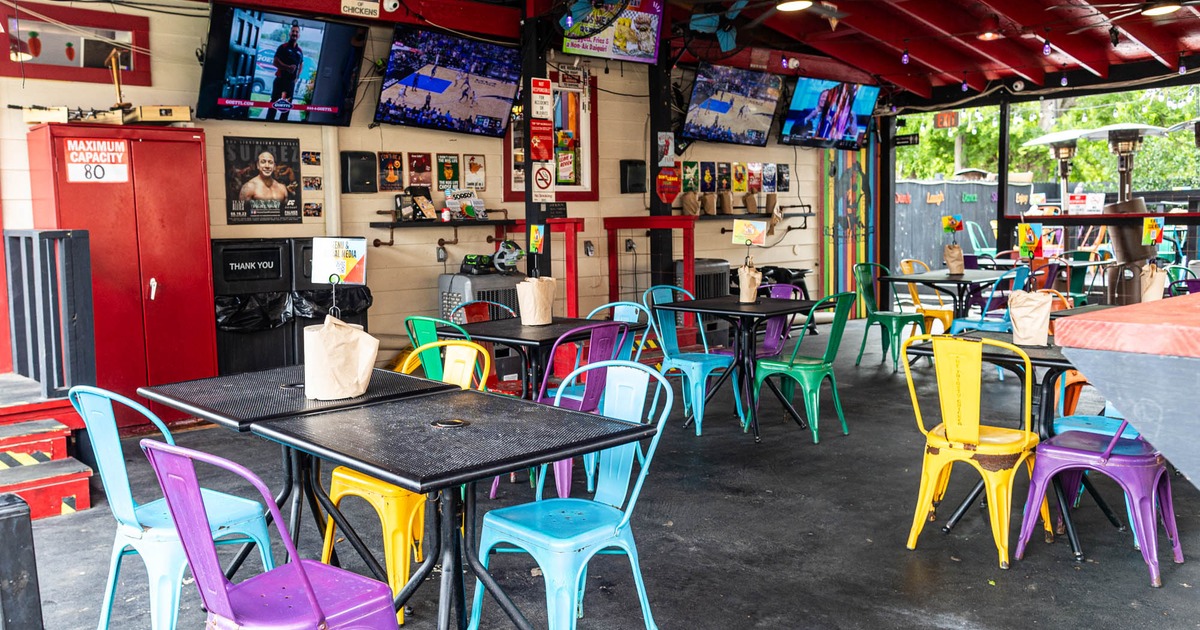 Covered terrace with chairs and tables, TVs on the wall