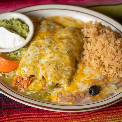 Enchilada smothered in green sauce, with sour cream, guacamole, rice, and beans.